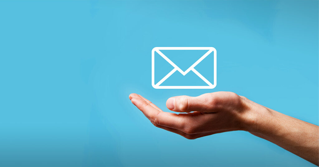 A hand holding an email envelope icon